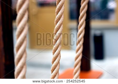 A Twisted Rope Of Yellow Color Close Up Against A Courtyard Background