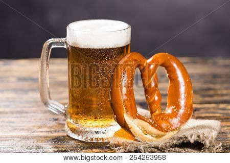 Alcohol, Liquid, Food Concept - A Huge Cup Of Beer On A Table With A Bagel