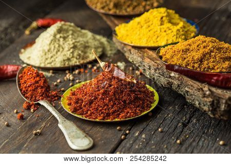 Heaps Of Various Ground Spices On Wooden Background. Georgian Spices, Indian Spices, Arabian Spices.