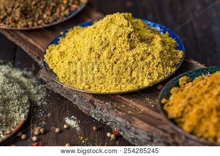 Heaps Of Various Ground Spices On Wooden Background. Georgian Spices, Indian Spices, Arabian Spices.