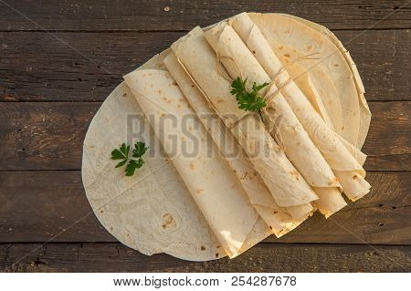 Armenian Flat Bread Lavash. Pita Bread On Black Wooden Background. Copy Space. Top View Or Flat-lay.