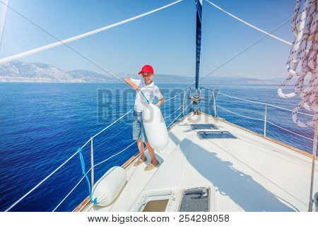 Cute Boy On Board Of Sailing Yacht On Summer Cruise. Travel Adventure, Yachting With Child On Family