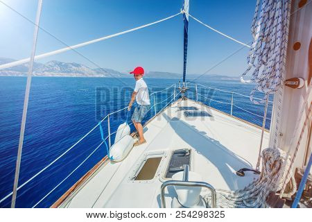 Cute Boy On Board Of Sailing Yacht On Summer Cruise. Travel Adventure, Yachting With Child On Family