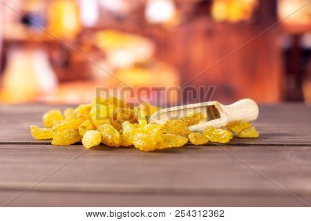 Lot Of Whole Dry Golden Raisins Sultana Variety With Wooden Scoop With Rustic Wood Kitchen In Backgr