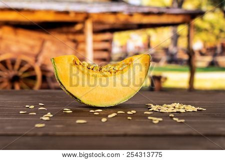 One Slice Of Fresh Melon Cantaloupe Variety With Seeds Around With Cart In Background