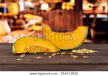 Group Of Two Slices Of Fresh Melon Cantaloupe Variety With Seeds Around With Rustic Wood Kitchen In 
