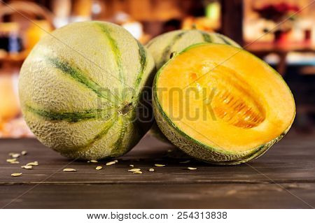 Group Of One Whole One Half Of Fresh Melon Cantaloupe Variety With Seeds Around With Rustic Wood Kit
