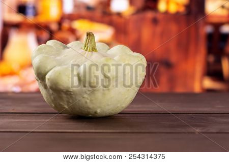 One Whole Summer White Pattypan Squash With Rustic Wood Kitchen In Background