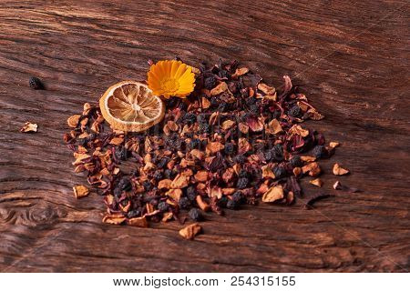 Black Dry Fruit Tea Leaves On Wooden Table. Selective Focus. Space For Text. Copyspace
