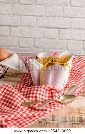 Portuguese Sponge Cake Wrapped In The Typical Paper Used On The Baking, On Wooden Background.