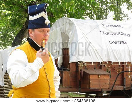 Moscow, Russia - August 2018: French Grenadier In Uniform Of 19th Century Smokes A Pipe In A Militar