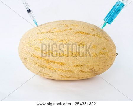Melon On A White Background In Which Enter Gmo And Nitrates, Close-up, Genetically Modified Organism