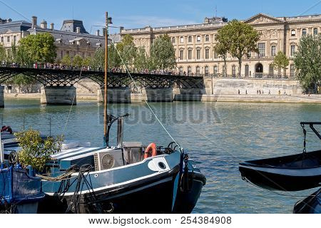 Paris, France - August 18, 2018: Pont Or Passerelle Des Arts With Old Houseboats Barges In The Foreg
