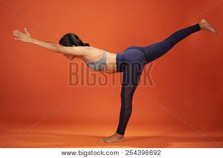 Warrior Three Yoga Pose. Woman Show Warrior Asana In Studio Background