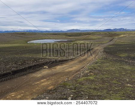 Dirt Mountain Road In Abandoned Green Landscape At Nature Reserve Fjallabak In Iceland With  Snow Co