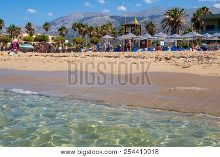 Malia, Crete, Greece - July 1, 2018: People Are Resting On A Sunny Day At The Beach In Malia, Crete,
