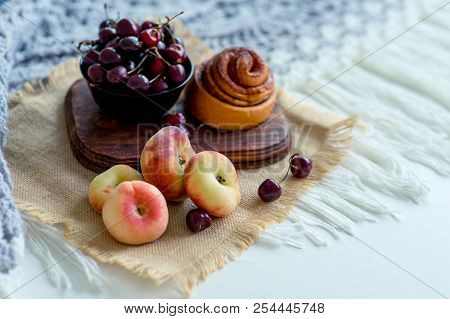 Homemade Cinnamon Buns In Glaze On A Dark Plate With Berries