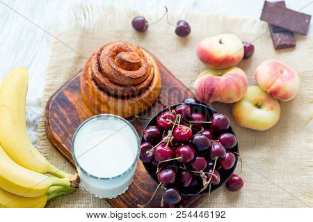 Homemade Cinnamon Buns In Glaze On A Dark Plate With Berries