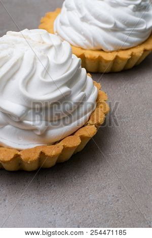 Delicious Merengue Dessert. Lemon Tartlet Tart With With Meringue On Grey Stone Concrete Table Backg