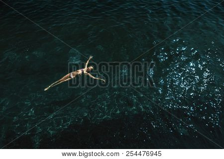 Aerial View Of A Woman Floating And Reraxing In The Sea