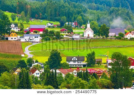 Norwegian Village Landscape With Meadows, Mountains, Church And Colorful Houses. Loen, Norway