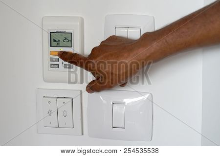 Male Hand Try To Turn On The New Air Condition In Room, In The Hotel Room. African Man Hands On The 