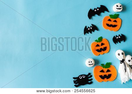 Top View Of Halloween Crafts, Orange Pumpkin, Ghost And Spide On Blue Background With Copy Space For