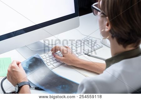 Digital Health Concept: Young Medical Doctor Working At A Desktop Computer. Female Practitioner At M