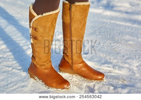 Leg Woman Winter Brown Fur Boots Walking On The Snow In A Winter Park. Closeup Outsole Of Warm Boot.