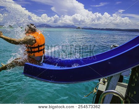 Asian Man Playing The Slider On The Boat With Amzing Idyllic Ocean And Blue In Vacation Time.summer 
