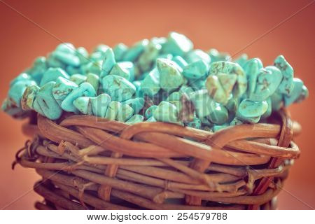 Pile Stones Of Raw Turquoise In Small Wooden Nest On A Brown Background. Blue And Green Color Stones