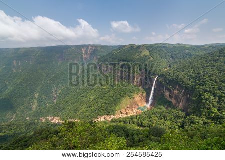 Nohkalikai waterfall surrounded by high cliffs and woodland and thick vegetation near Cherrapunji, Meghalaya, India.