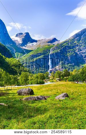 Pathway To Briksdal Or Briksdalsbreen Glacier In Olden, Norway With Green Mountains, Snow And Waterf