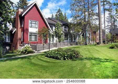 Beautiful new contempory suburban attached townhomes with colorful summer gardens in a Canadian neighborhood.