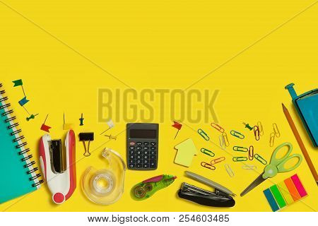 Multiple School And Office Suplies And Gadget Lying On A Yellow Background