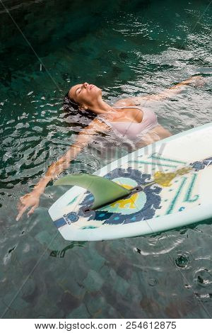 Beautiful Young Woman In Sexy Bikini Relax In Pool With Her Longboard Single Fin Surfing Board Under