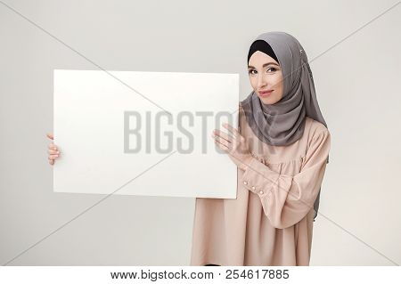 Place For Your Islamic Text Or Picture. Muslim Woman Holding Blank White Paper, Copy Space