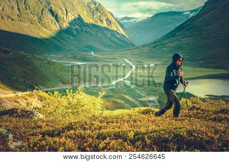 Nordic Walking On The Mountain Trail. Caucasian Men In His 30s Enjoying Sunny Summer Day In The Norw