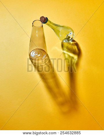 A transparent glass flasks empty on a yellow paper background with soft shadows and copy space. Laboratory glasses at experiment in chemistry laboratory.