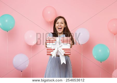 Portrait Of Fascinating Happy Young Woman In Blue Dress Holding Red Box With Gift Present On Pastel 