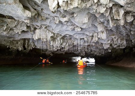 Cayakers Entering A Sea Cave In Ha Long Bay