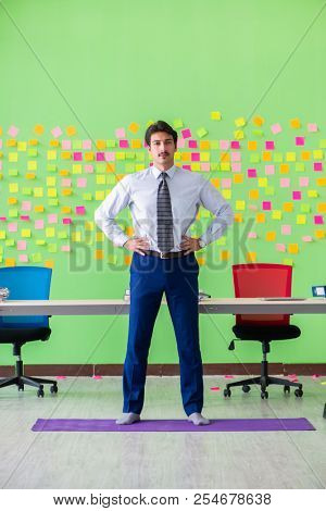 Man in the office with many conflicting priorities doing exercis