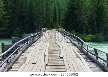 old wooden bridge through Argut River. Russia. Siberia