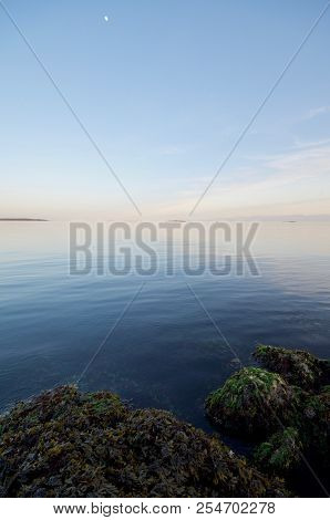 Rocks And Calm Sea Of Juan De Fuca Straits At Sunset, With The Moon In A Clear Sky, Cattle Point, Oa