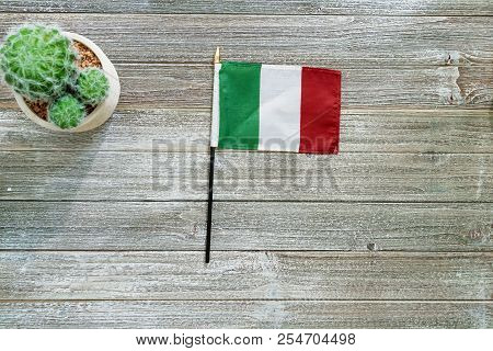 Itialian Flag On A Gray Wooden Desktop