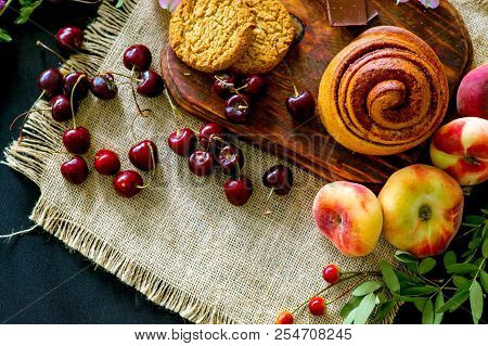 Homemade Cinnamon Buns In Glaze On A Dark Plate With Berries