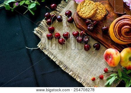 Homemade Cinnamon Buns In Glaze On A Dark Plate With Berries