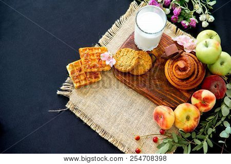 Homemade Cinnamon Buns In Glaze On A Dark Plate With Berries