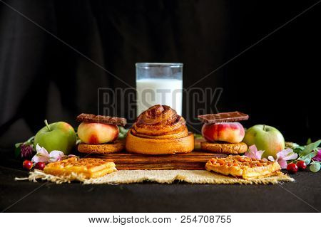 Homemade Cinnamon Buns In Glaze On A Dark Plate With Berries