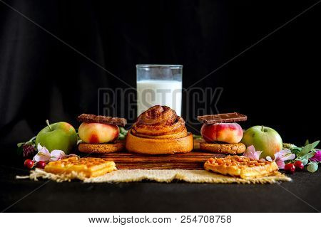Homemade Cinnamon Buns In Glaze On A Dark Plate With Berries